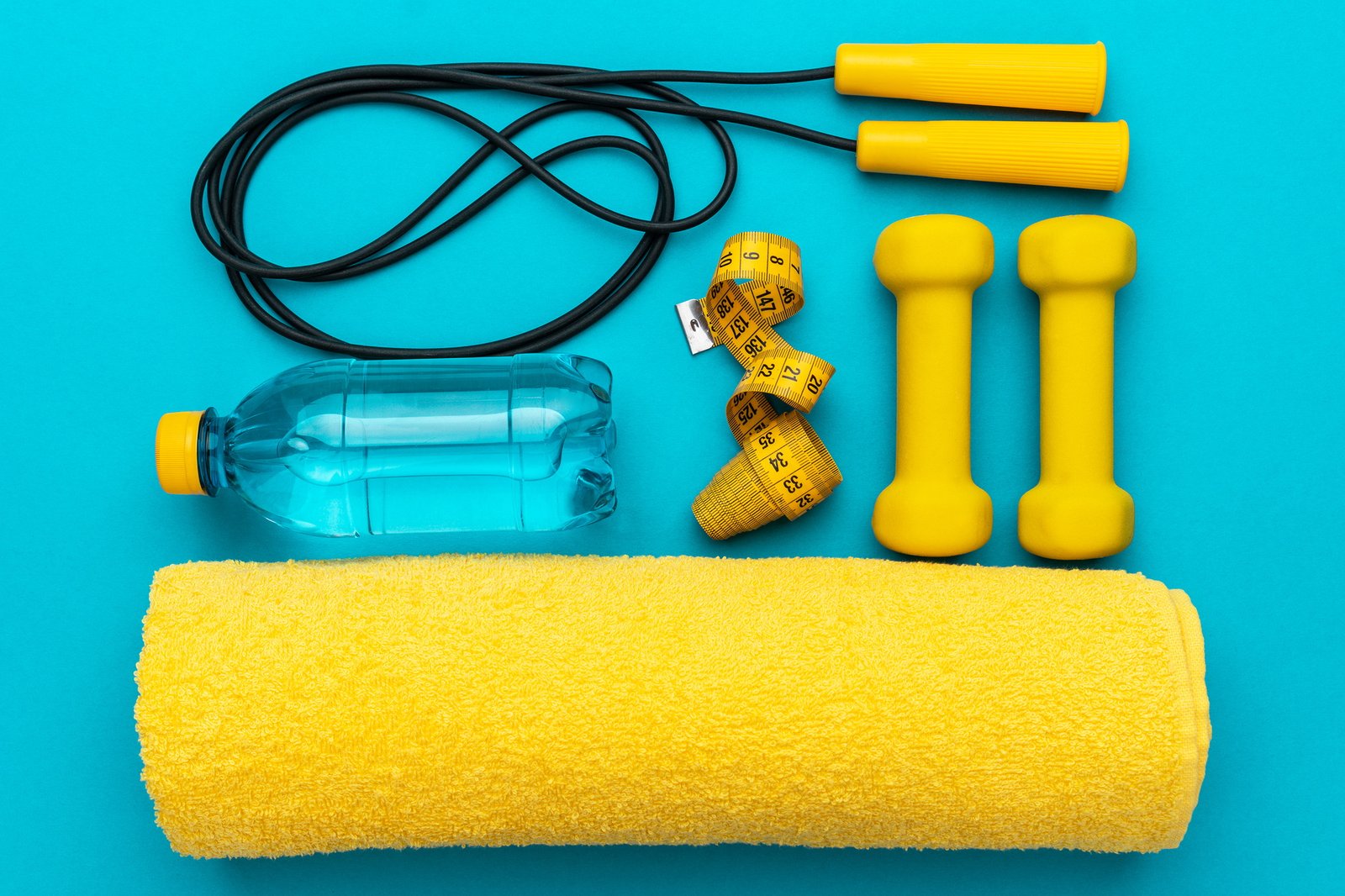 Flat Lay Photo Of Yellow Fitness Equipment In Oder Over Turquoise Blue Backgound