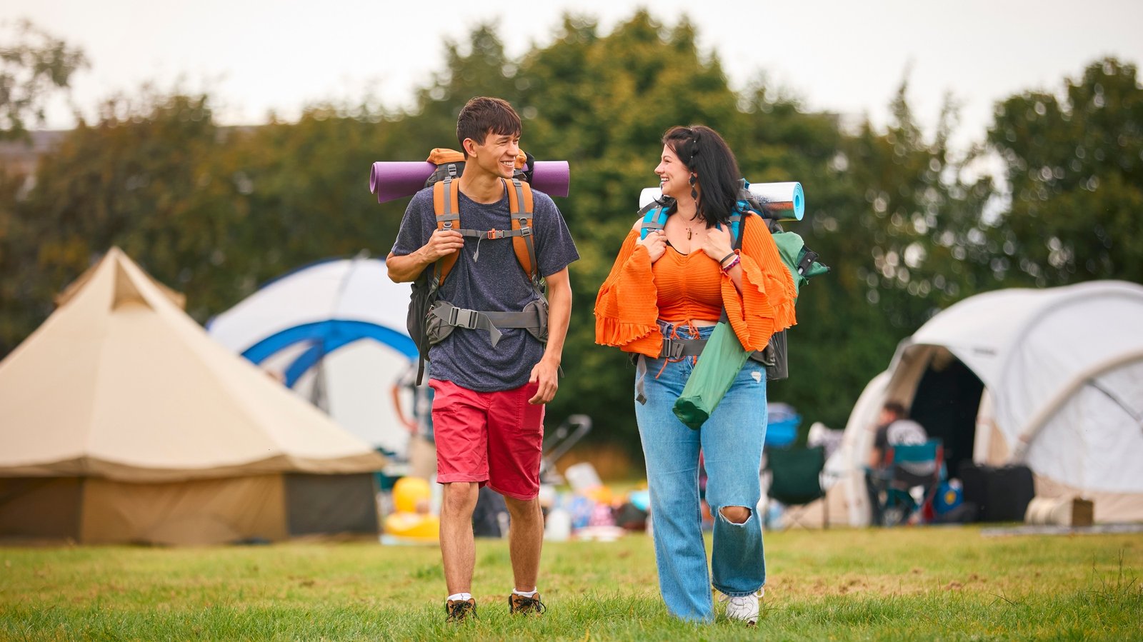 Young Couple Meeting At Summer Music Festival With Camping Equipment